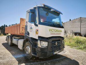 Camion-benne de chantier Renault de la société VICTORIANA, garé en extérieur