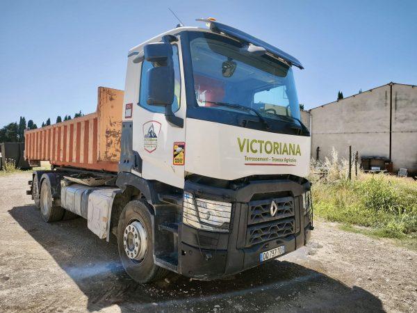 Camion-benne de chantier Renault de la société VICTORIANA, garé en extérieur