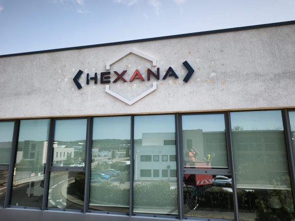 Façade d’un bâtiment avec l’enseigne HEXANA