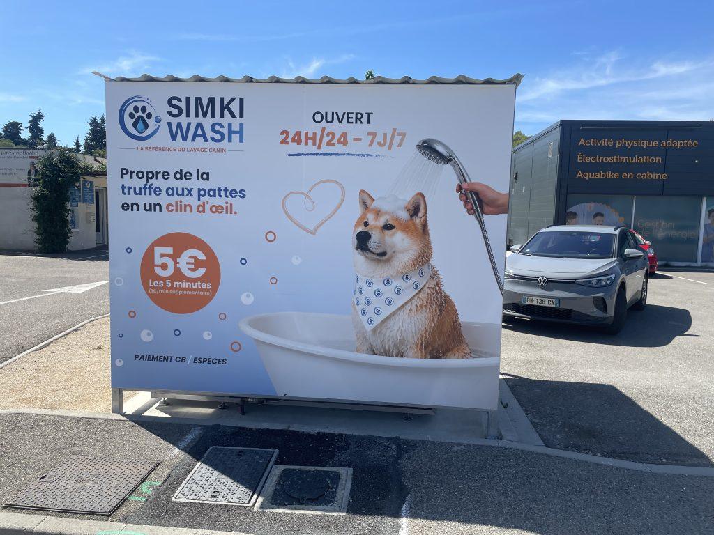 Face avant du box Simki Wash ouvert 24h/24 avec visuel chien sous la douche