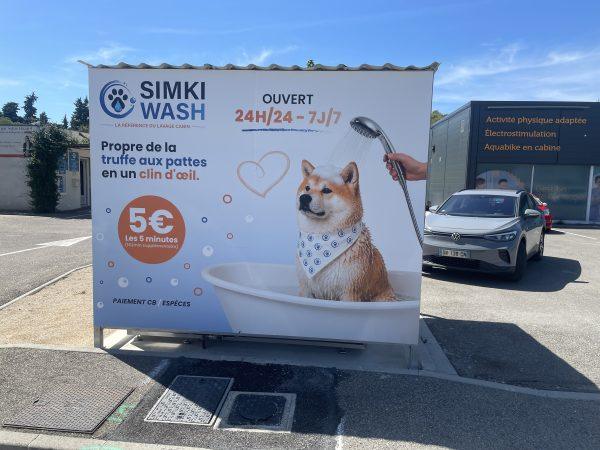 Face avant du box Simki Wash ouvert 24h/24 avec visuel chien sous la douche