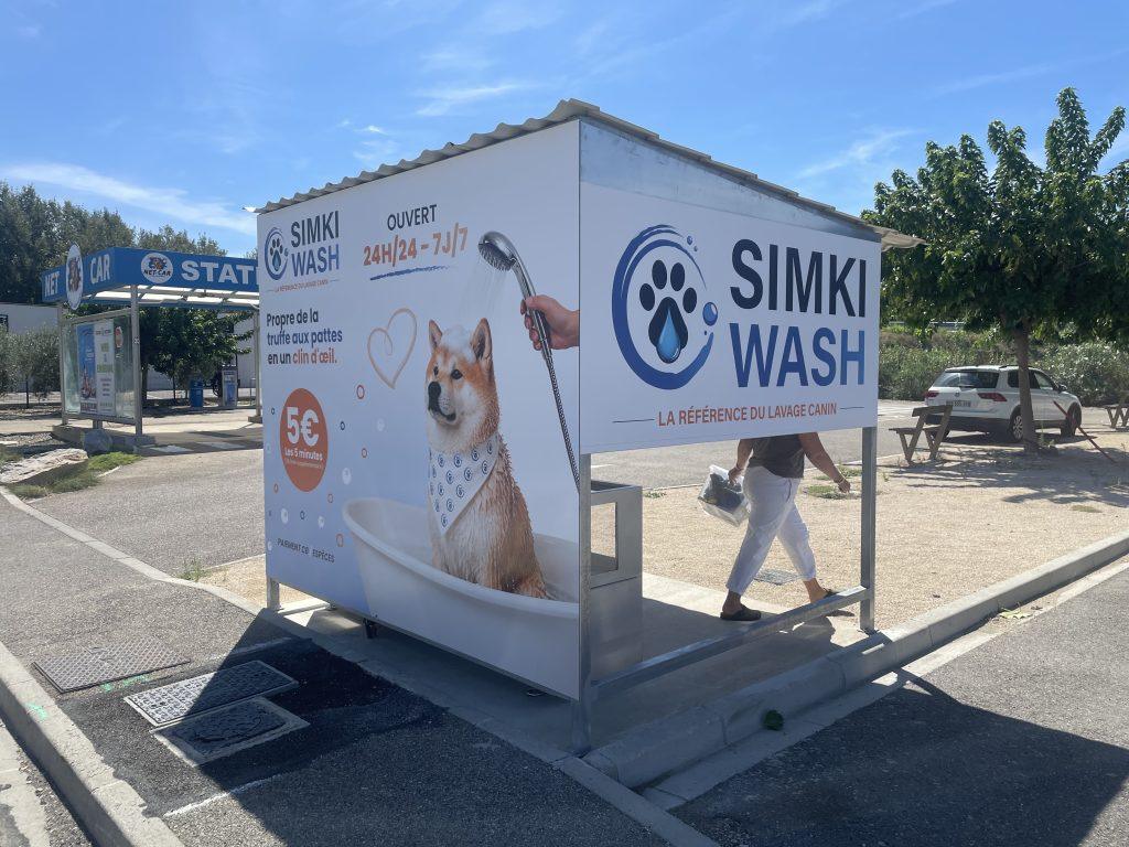 Habillage adhésif d'un box de lavage canin Simki Wash avec visuel chien Shiba sur une station de lavage