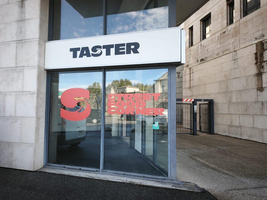 Vitrine vitrée avec logo rouge «Street Food Corner» et enseigne Taster placée au-dessus