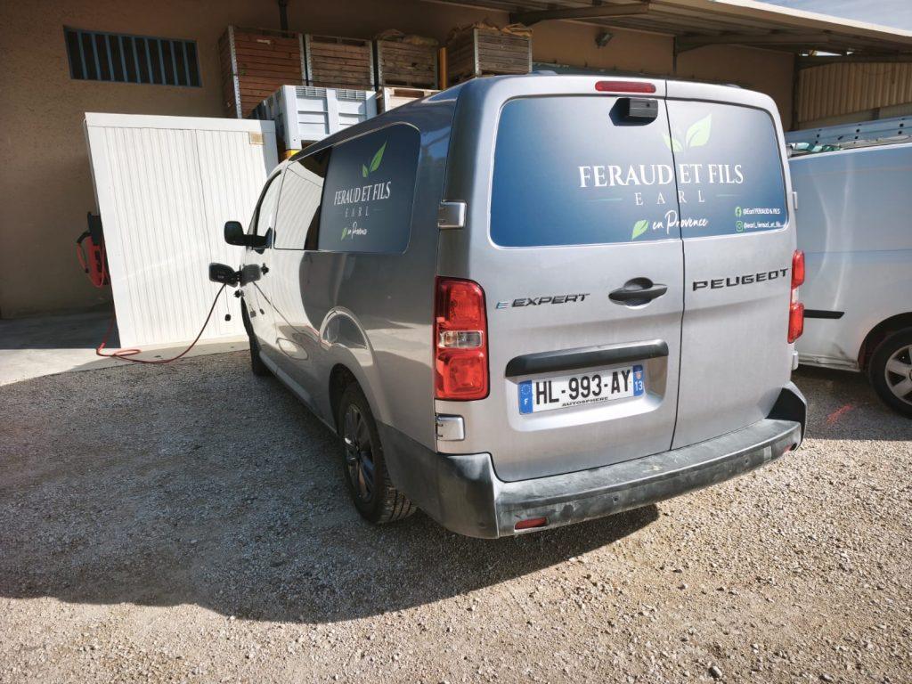 Arrière du fourgon Peugeot argent marqué Feraud et Fils sur grand adhésif bleu