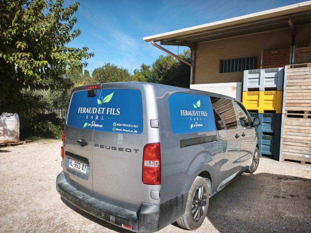 Vue 3/4 arrière d’un fourgon Peugeot gris avec adhésif bleu Feraud et Fils, habillage adhésif véhicule
